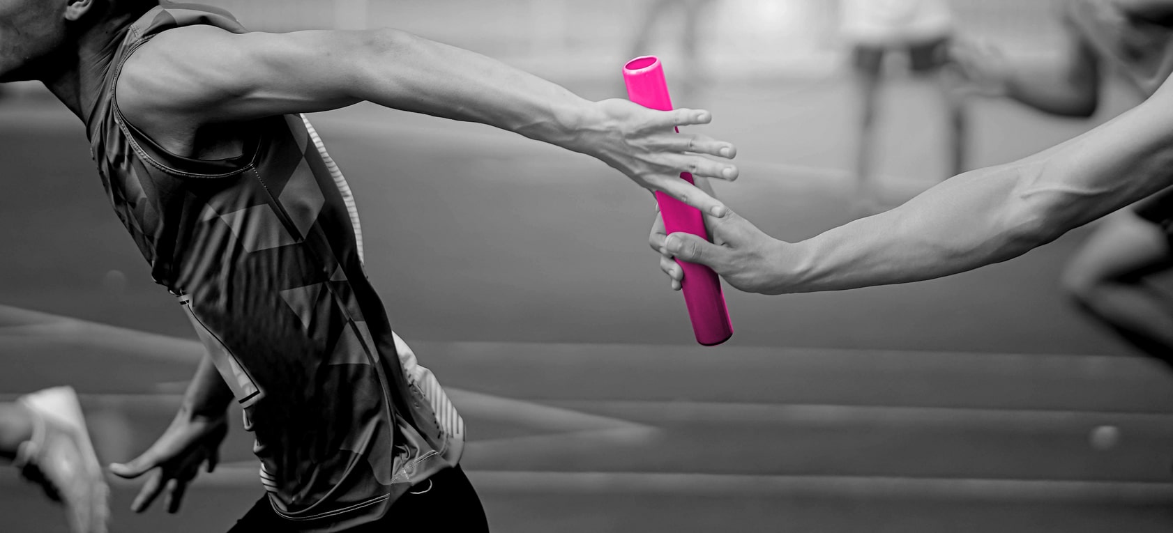 Professional,Athlete,Passing,A,Baton,To,The,Partner,Against,Race